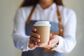 A waitress holding and serving a paper cup of hot coffee Royalty Free Stock Photo