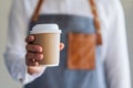 A waitress holding and serving a paper cup of hot coffee Royalty Free Stock Photo