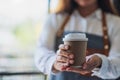 A waitress holding and serving a paper cup of hot coffee Royalty Free Stock Photo