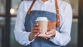 A waitress holding and serving a paper cup of hot coffee Royalty Free Stock Photo