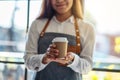 A waitress holding and serving a paper cup of hot coffee Royalty Free Stock Photo