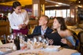 Positive young couple making order at restaurant Royalty Free Stock Photo