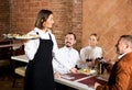 Waitress placing order in front of guests Royalty Free Stock Photo