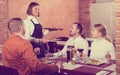 Waitress placing order in front of guests Royalty Free Stock Photo