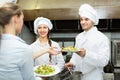 Waitress with plates at kitchen Royalty Free Stock Photo