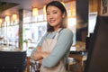 Waitress, portrait and Asian woman with arms crossed at cafe, coffee shop or store. Face, smile and confident barista Royalty Free Stock Photo