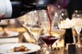 Waitress pour red wine in the glass on the table in restaurant Royalty Free Stock Photo