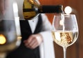 Waitress pouring wine into glass in restaurant, Royalty Free Stock Photo