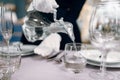 Waitress pours drinks into glasses, table setting Royalty Free Stock Photo