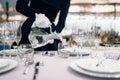 Waitress pours drinks into glasses, table setting Royalty Free Stock Photo