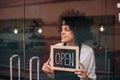 Waitress putting an open sign on the glass door Royalty Free Stock Photo