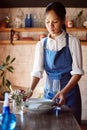 Waitress, restaurant and clean at table for plate, glass and cutlery in apron at work. Woman, cafe or coffee shop