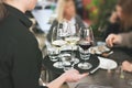 waitress at restaurant serving white and red wine