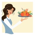 The waitress serves a platter of vegetables on a tray. A woman holds a plate decorated with fruits and vegetables for