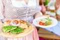 Waitress serving Bavarian food in beer garden