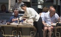 Waitress serving beverages at touristic sunny terrace bar