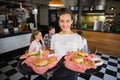 Waitress serving burger while customers sitting in restaurant Royalty Free Stock Photo
