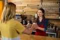 Waitress serving a cup of coffee to customer in cafÃÂ© Royalty Free Stock Photo