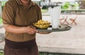 Waitress serving french fries in tray at restaurant outdoors.