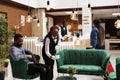 Waitress serving hotel guest in lobby Royalty Free Stock Photo