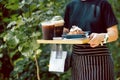 Waitress serving iced coffee and croissants in cafe outdoor. Royalty Free Stock Photo