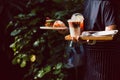 Waitress serving iced coffee and croissants in cafe outdoor. Royalty Free Stock Photo