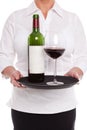 Waitress serving red wine with glass and bottle on a tray. Royalty Free Stock Photo