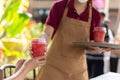 Waitress serving strawberry shake to customer at cafe.