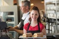 Waitress smiling at the camera showing cakes