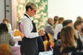 Waitress takes orders at the diners` table of crowded restaurant Royalty Free Stock Photo