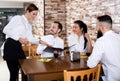 Waitress taking order at table of people