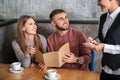 Waitress taking and order from young couple in restaurant Royalty Free Stock Photo