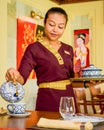 Waitress wearing uniform in the thai restaurant serving tea