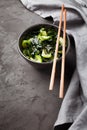 Wakame salad raw seaweed with cucumber slices and sesame in bowl on dark gray background close-up Royalty Free Stock Photo