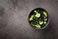 Wakame salad raw seaweed with cucumber slices and sesame in bowl on dark gray background Royalty Free Stock Photo