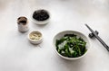 Wakame seaweed in a bowl with soy sauce and sesame seeds on gray background. Royalty Free Stock Photo