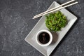 Wakame seaweed salad with sesame seeds and chili pepper in a bowl on black stone background. Top view Royalty Free Stock Photo