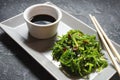 Wakame seaweed salad with sesame seeds and chili pepper in a bowl on black stone background Royalty Free Stock Photo