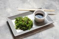 Wakame seaweed salad with sesame seeds and chili pepper in a bowl on concrete background Royalty Free Stock Photo