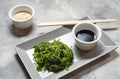 Wakame seaweed salad with sesame seeds and chili pepper in a bowl on concrete background Royalty Free Stock Photo