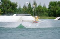 Wake boarding rider jumping trick with water splash in wake park and drone. Royalty Free Stock Photo