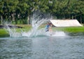 Wake boarding rider jumping trick with water splash.
