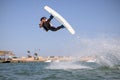 Wake boarding sportsman jumping high trick with big water splash in the cable park, active water sports Royalty Free Stock Photo