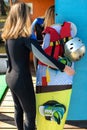 A wake boarding girl collects equipment - a wakeboard, boots, a helmet and a wakesurfing vest Royalty Free Stock Photo