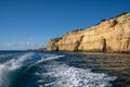 Wake of a high speed motorboat and view of ocean with cliffs Royalty Free Stock Photo