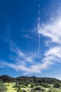 The wake of jet aircraft in the sky over a rural landscape