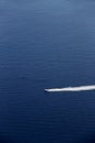 Wake of a motorboat against a deep blue sea