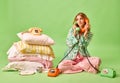 Wake up calls. Full length portrait of dissatisfied young woman in pajama talked to two retro phones isolated on pastel