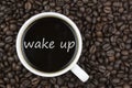 Wake up text in coffee cup on coffee beans background