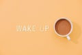 WAKE UP text with a cup of coffee with shadow on pink background Royalty Free Stock Photo